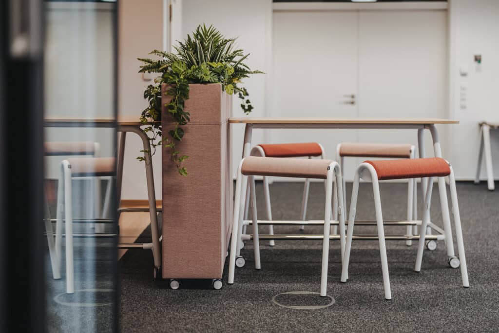Moderner Arbeitsbereich mit Pflanzen und Hockern