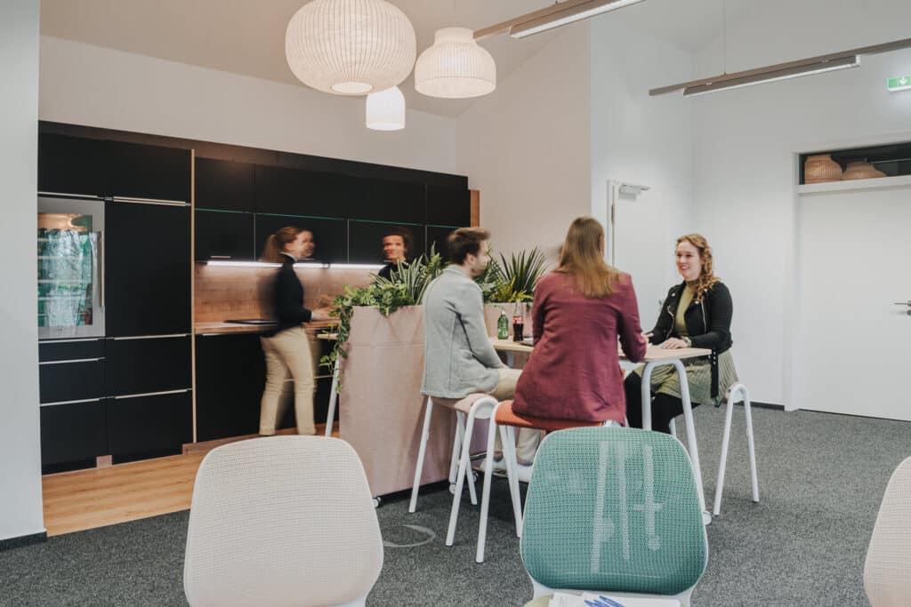 Menschen in Büro-Küche unterhalten sich