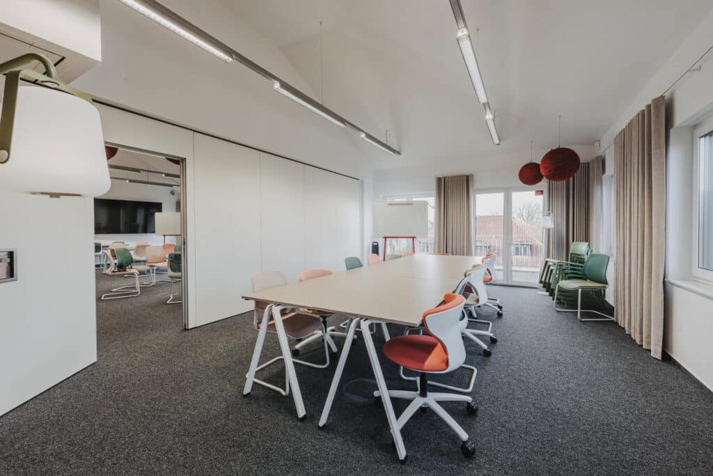 Moderner Konferenzraum mit bunten Stühlen und Tisch