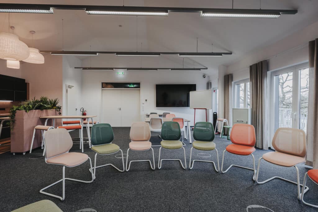 Moderner Seminarraum mit Stühlen und Whiteboard.